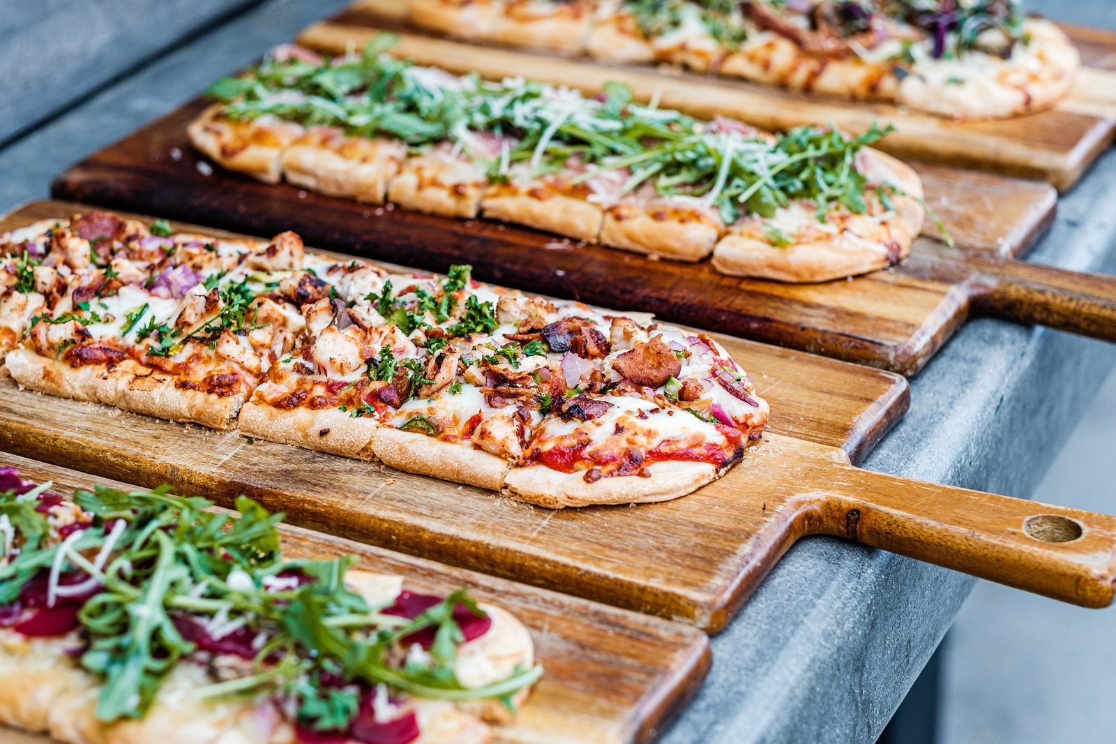 Flatbread pizzas served on wooden boards